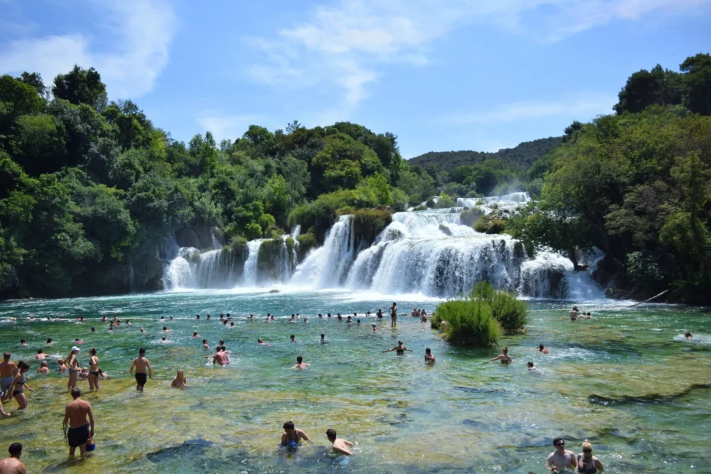 people swimming in waterfalls croatia krka vs plitvice national park
