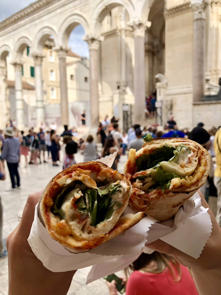 two chicken wraps being held up in split croatia dalmatians palace, street food in croatia