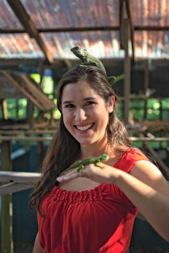 kate storm posing with two green iguanas at the green iguana project, one of the best things to do in belize