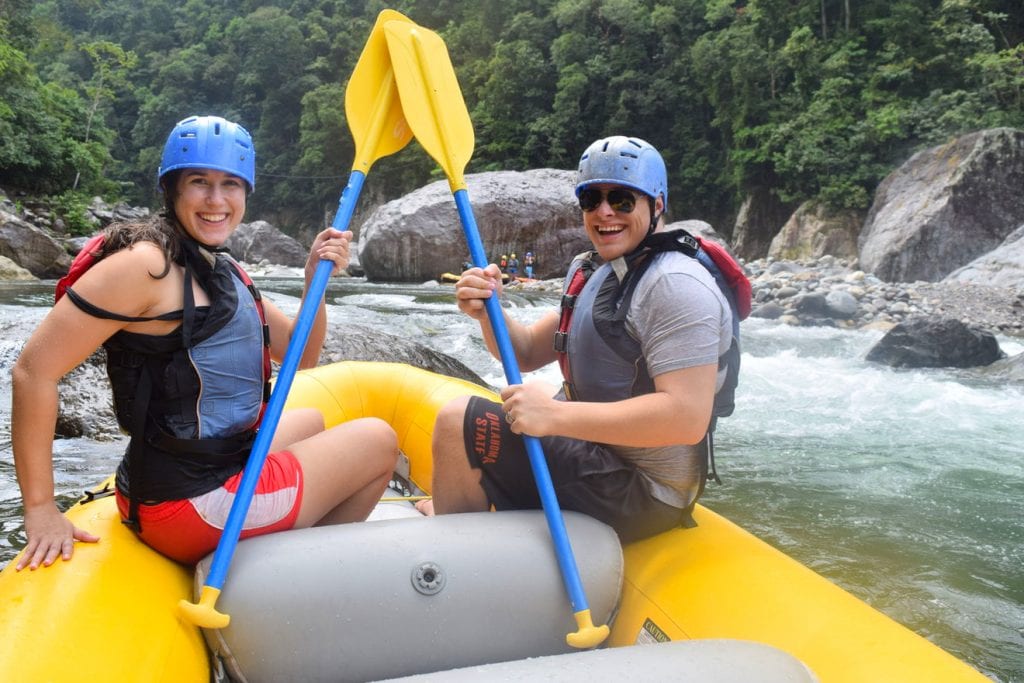 kate storm and jeremy storm sitting on a raft and preparing to go whitewater rafting in honduras