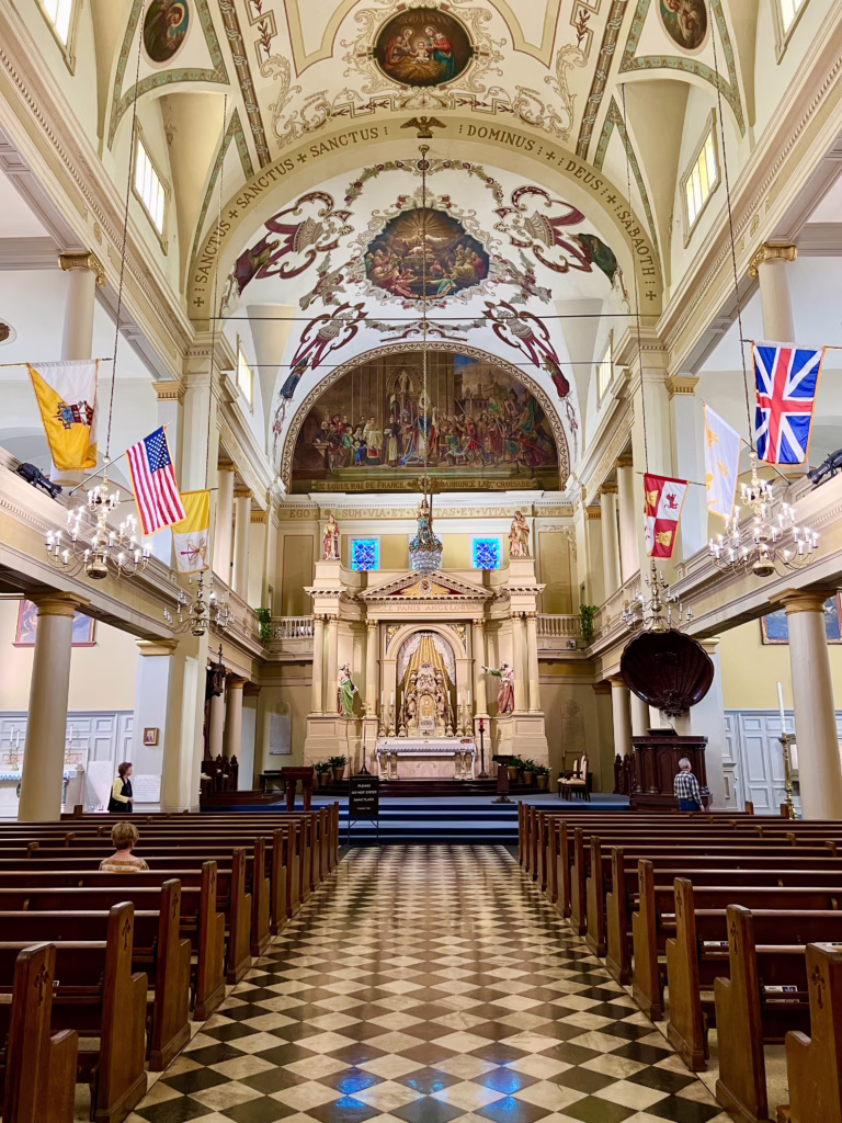 interior of st louis cathedral in new orleans with checkered tile and colorful flags inside