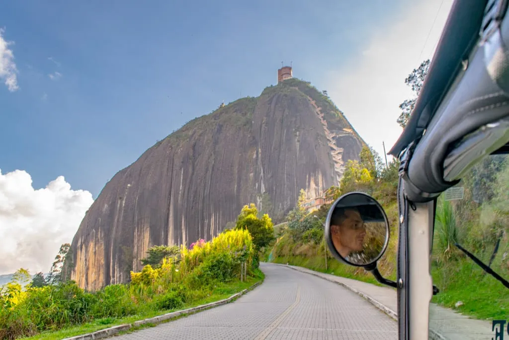 el penol as seen from the inside of a tuk tuk driving along the road that is approaching the rock of gautape colombia
