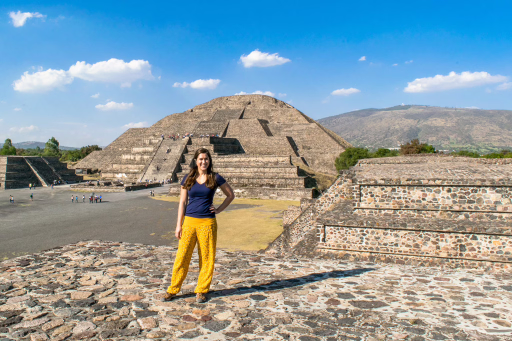kate storm standing on a small pyramid overlooking teotihuacan on one od the best days trips from mexico city things to do