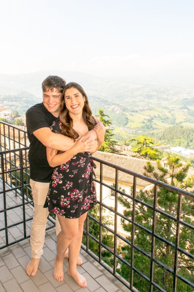kate storm and jeremy storm standing on the balcony of their hotel room at hotel la rocca when visiting san marino things to do