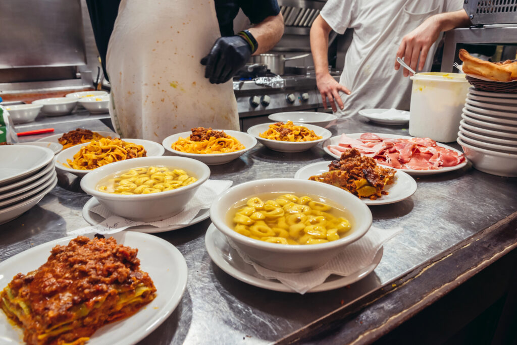 plates of traditional emilia-romagnan cuisine getting ready to be served at a restaurant in bologna italy