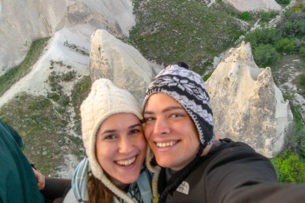 kate storm and jeremy storm taking a selfie in cappadocia hot air balloon with rock formations visible below