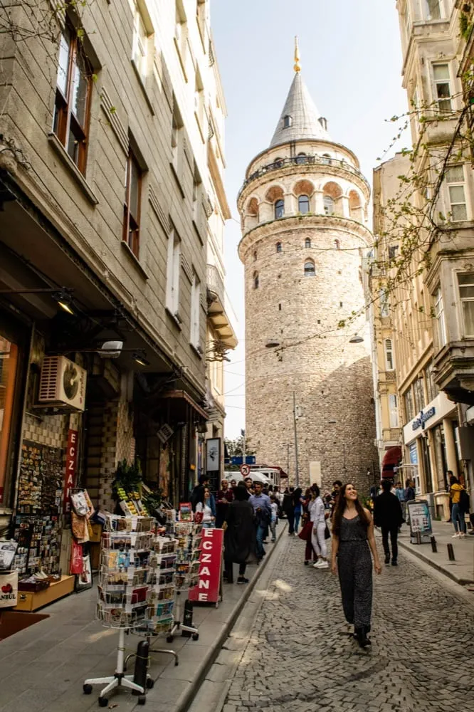 kate storm walking downhill with galata tower behind her, one of the best places to visit in istanbul turkiye
