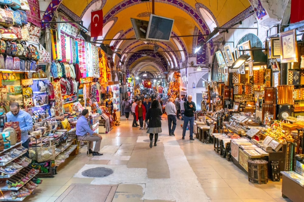 hallway of the grand bazaar, one of the best places to visit in istanbul in 2 days. both sides of the hall are lined with goods and the ceiling is painted yellow