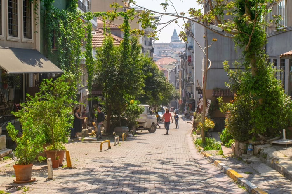 view of quiet istanbul street in cukurkuma with view of galata tower in the distance