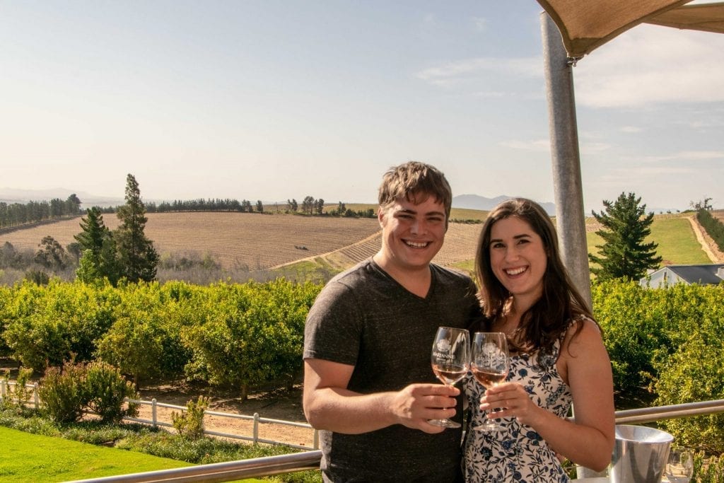 kate storm and jeremy storm holding up wine glasses during a cape winelands day trip from cape town travel guide