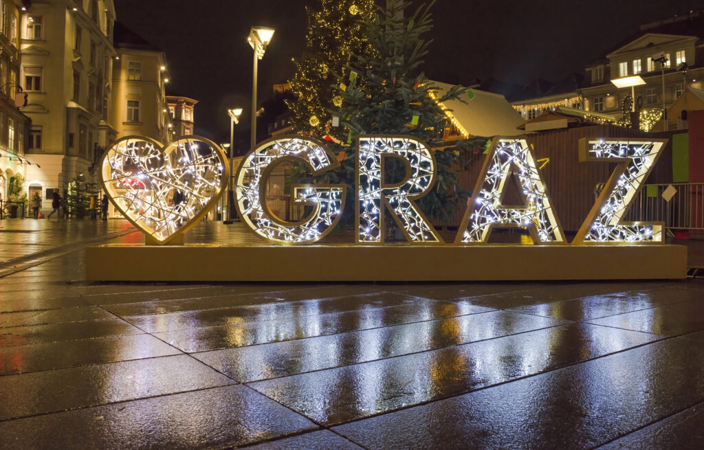 photo of heart graz sign made out of holiday lights lit up at night at a graz austria christmas market