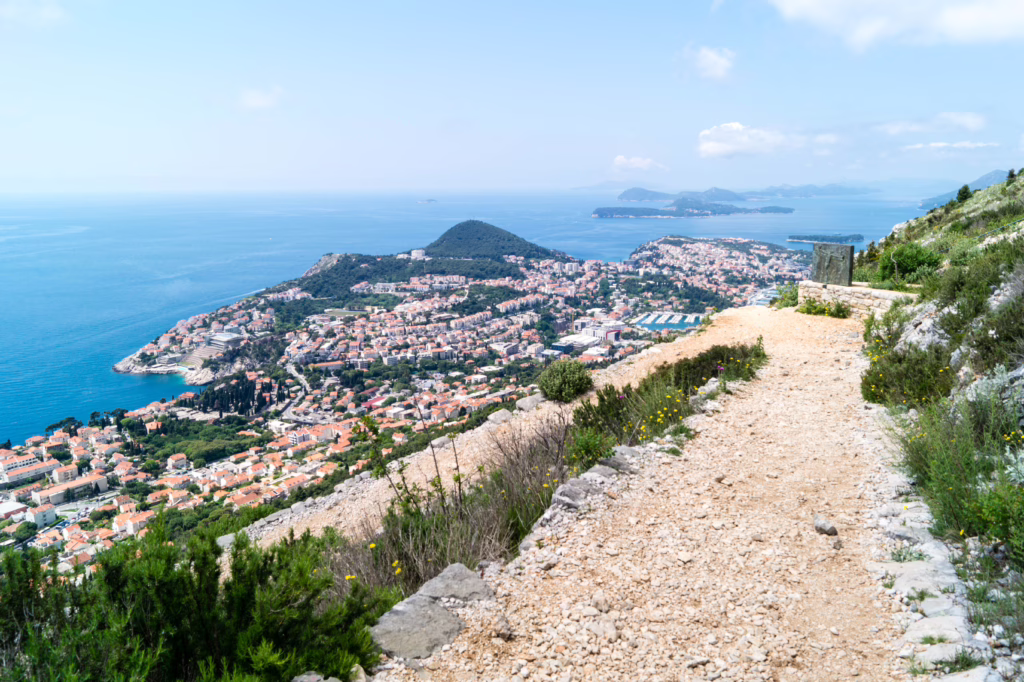 view of mount srd gravel hiking trail with dubrovnik croatia cityscape visible in the distance