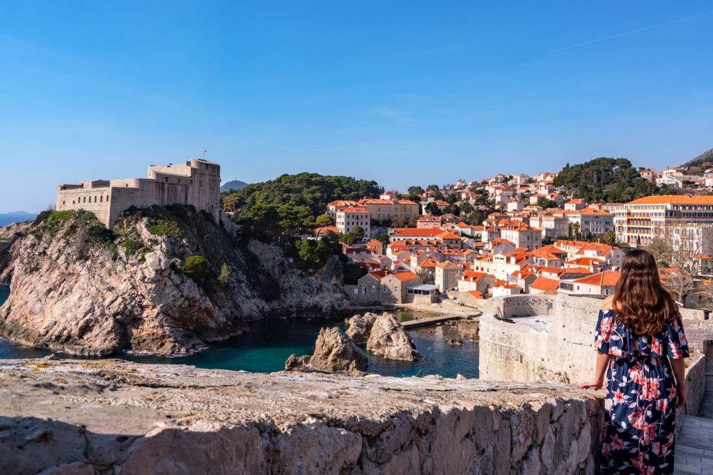 kate storm standing on dubrovnik city walls overlooking lovrjenac fortress and terracotta rooftops
