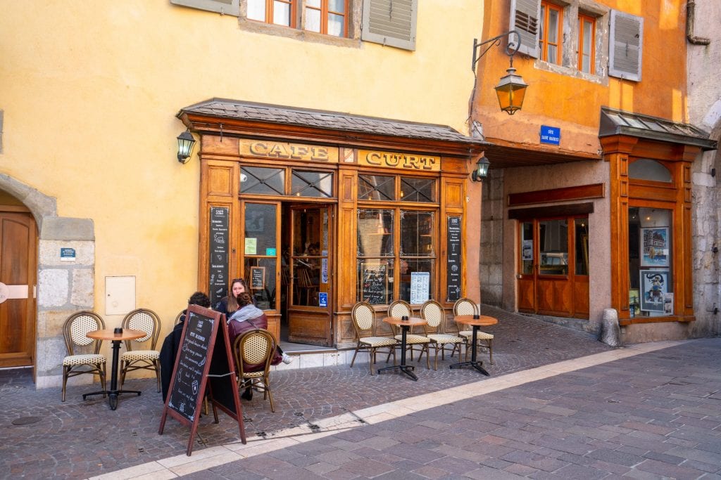 exterior of annecy restaurant set on a yellow building in historic center