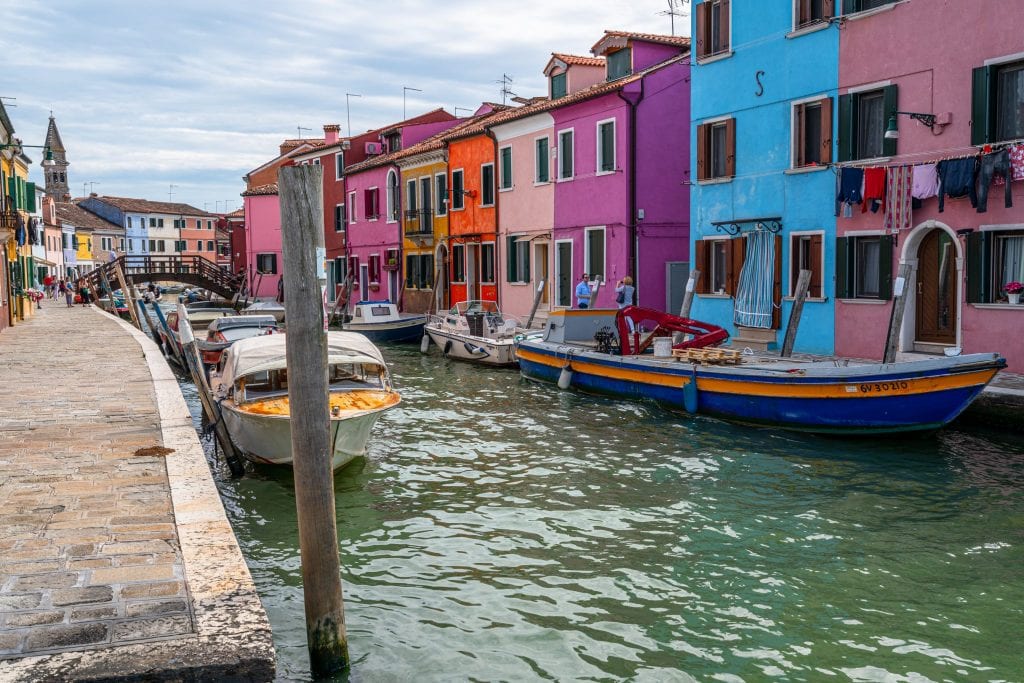 view of a canal on burano island venice with colorful buildings visible in the background