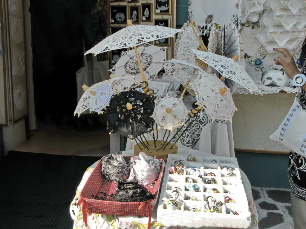 collection of burano lace umbrellas on display on burano venice day trip