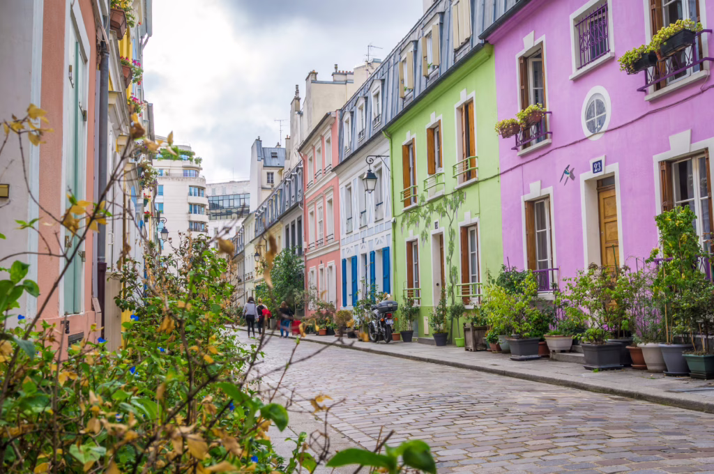 colorful pastel houses lining a cobblestone street in Rue Cremieux, a fun place to visit in paris off the beaten track