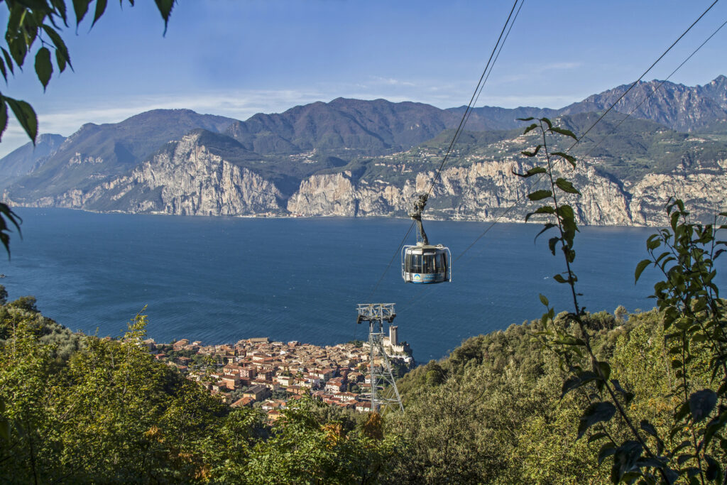 view of lake garda italy with cable car and village of malcesine visible in the distance