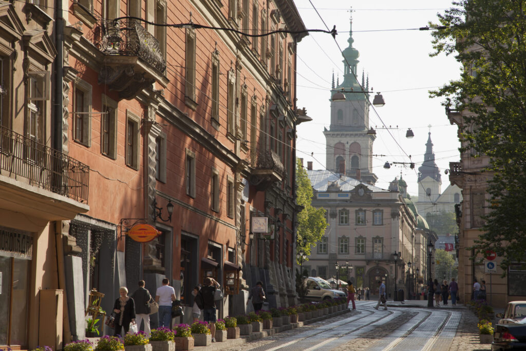 street in the historic center of lviv ukraine with church visible at the end of the street and tram lines running above it