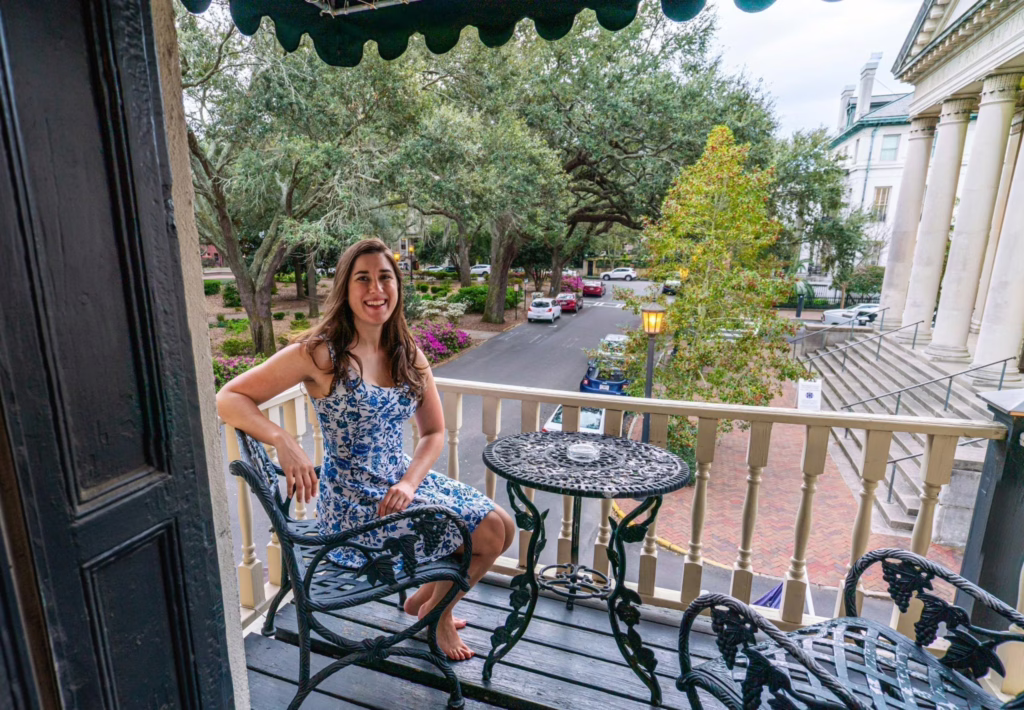 Kate Storm sitting on a balcony overlooking Chippewa Square at Foley House Inn during a long weekend in Savannah GA