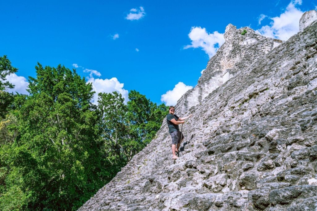 jeremy storm climbing a mayan pyramid at becan, one of the best archaeological sites in mexico