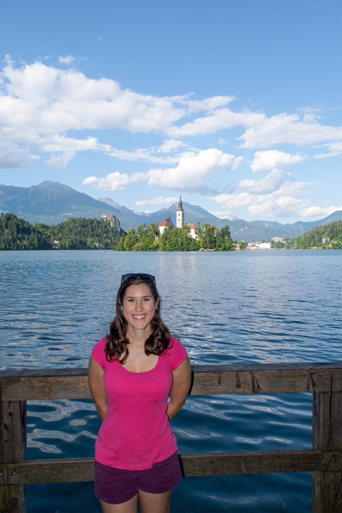 kate storm standing on the edge of lake bled in slovenia with island visible behind her