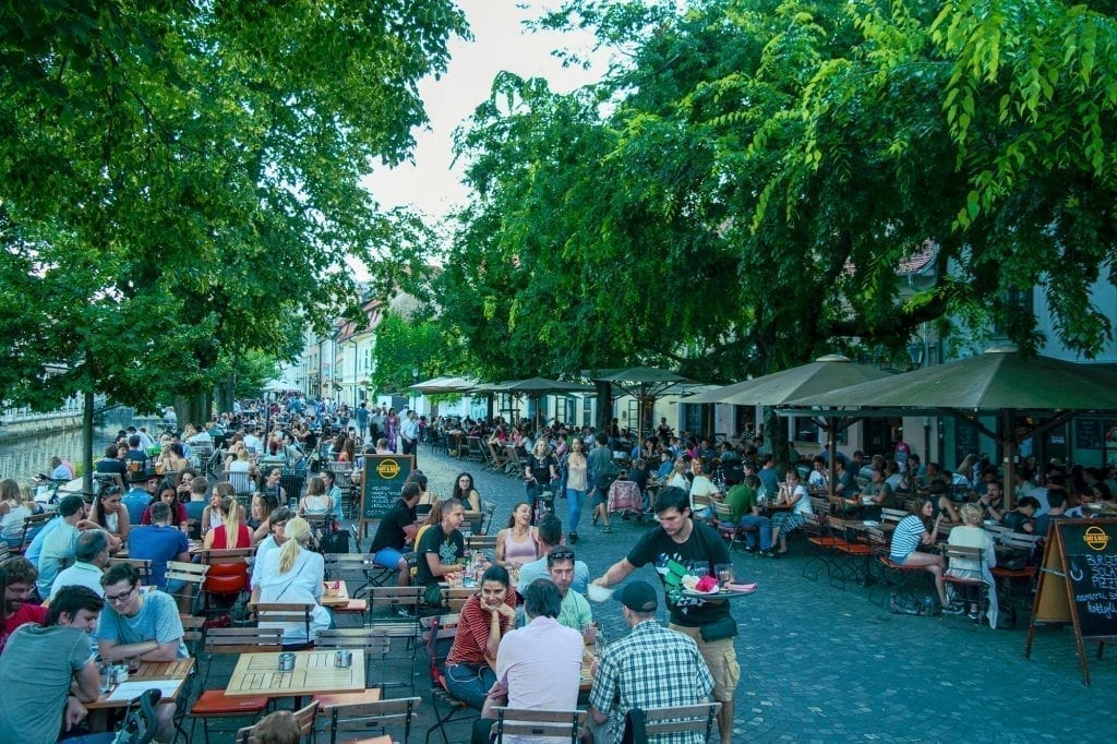 groups of people dining outside along a pedestrian street in ljubljana slovenia