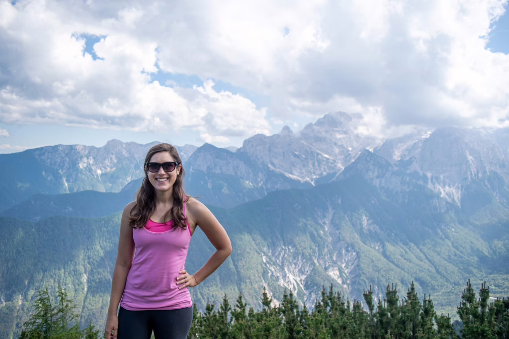 kate storm standing in triglav national park slovenia with mountains behind her