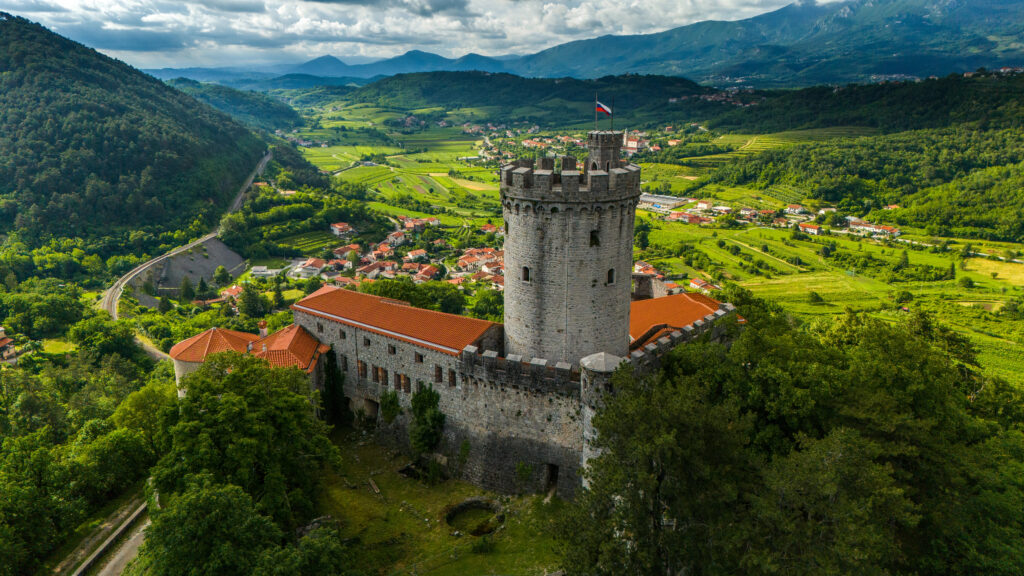 aerial view of rihemberk castle in slovenia with village of branik visible behind and below it
