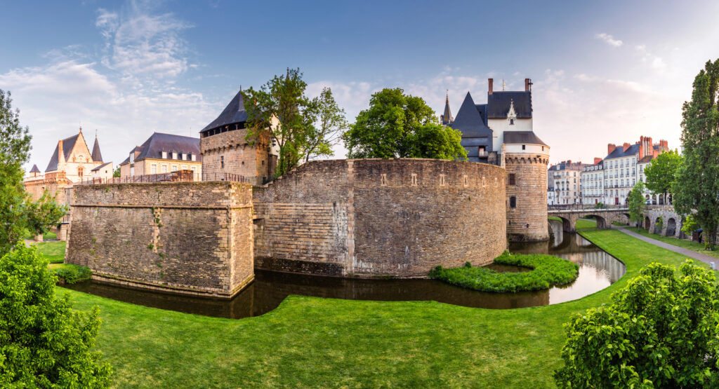 stone walls of the castle of the dukes in nantes france as seen from across the lawn