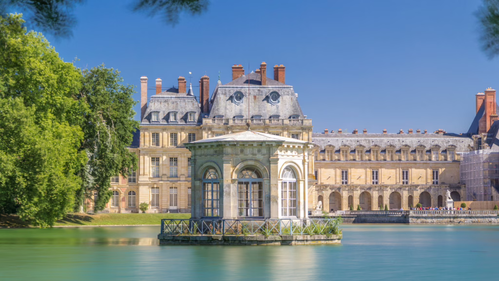 exterior of chateau de fontainbleau with pond in the foreground, one of the best day trips from paris by train