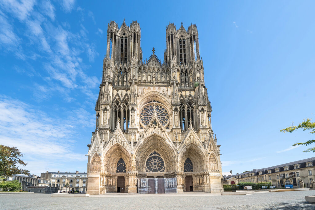 front facade of notre dame of reims, gothic cathedral as seen on a sunny day