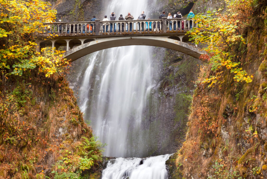 multnomah falls oregon seen close up in the fall with a bridge full of people admiring it in the foreground