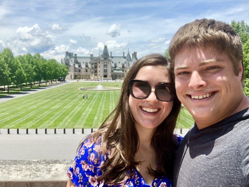 kate storm and jeremy storm taking a selfie in front of biltmore house, one of the best things to do in asheville north carolina