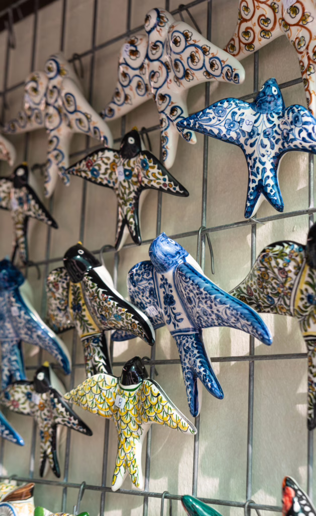 painted portuguese swallows hanging on a wall, for sale as some of the best souvenirs from portugal