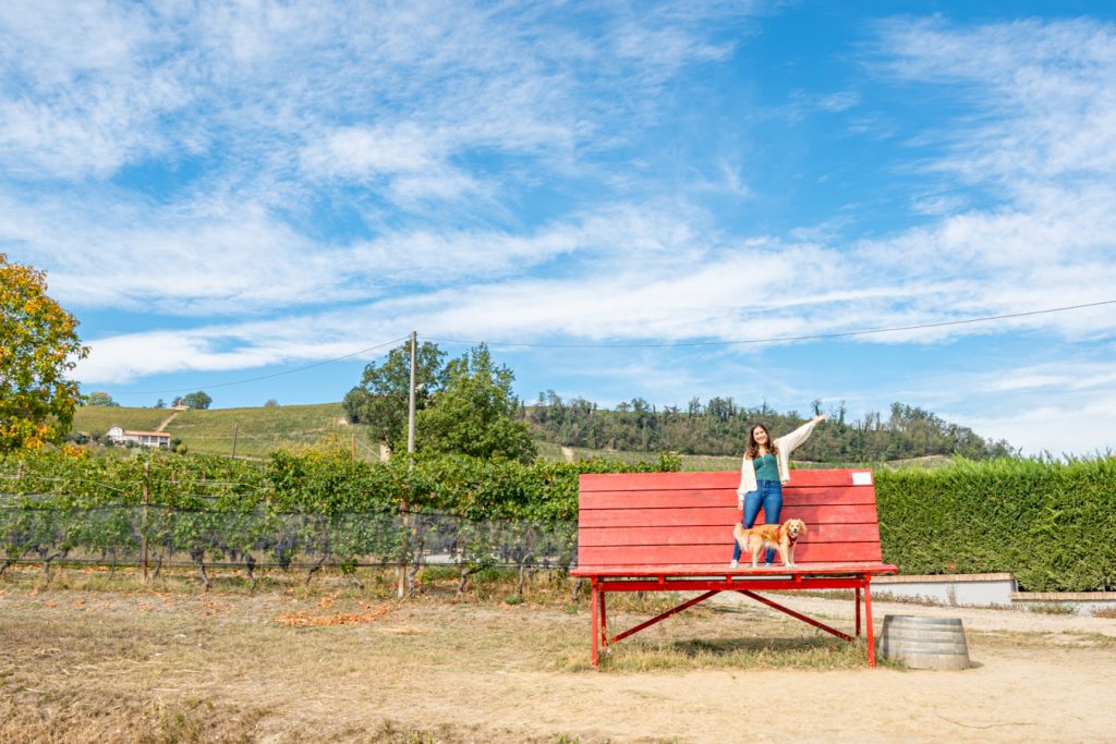 kate storm and ranger storm standing on the giant red bench that is a roadside attraction in la morra langhe piedmont