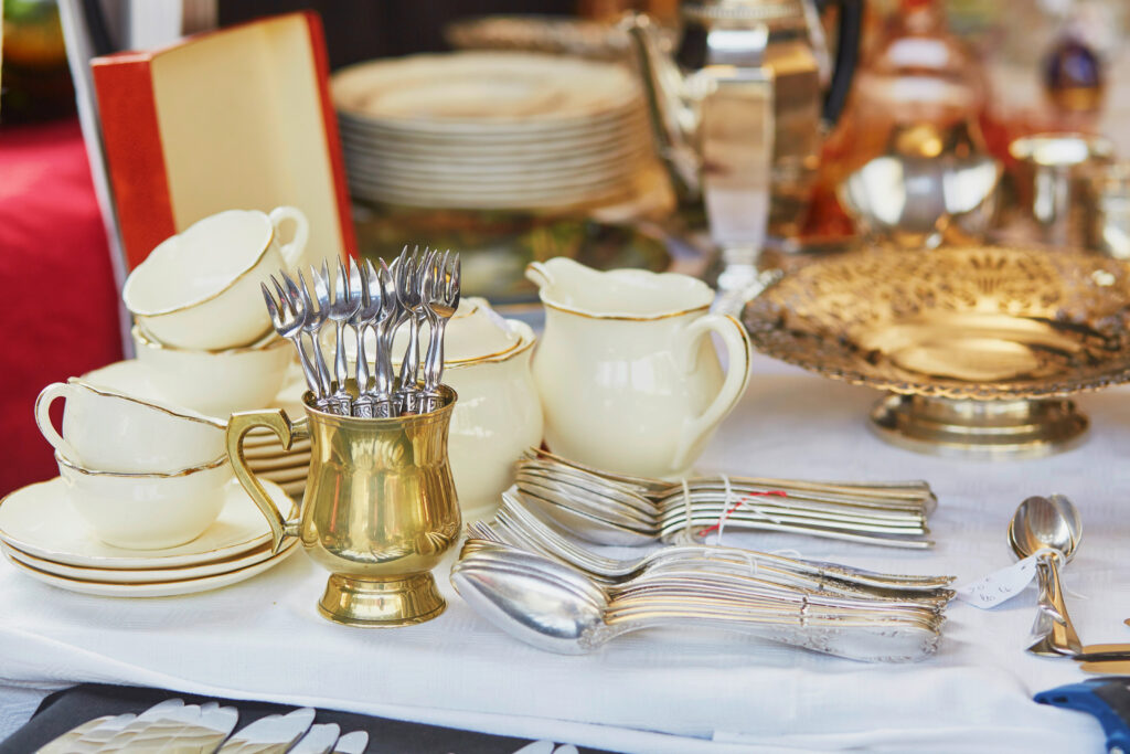 collection of dishware and silverware for sale at a flea market in paris shopping ideas