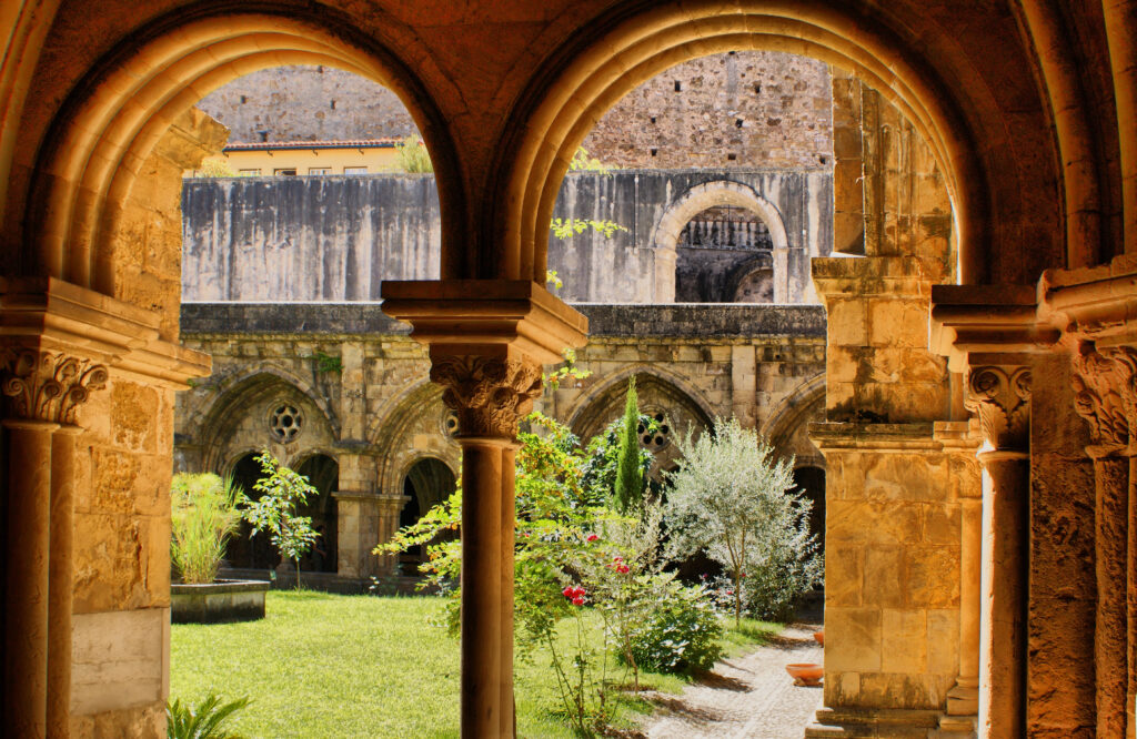 cloister in coimbra portugal with courtyard visible through the stone arches