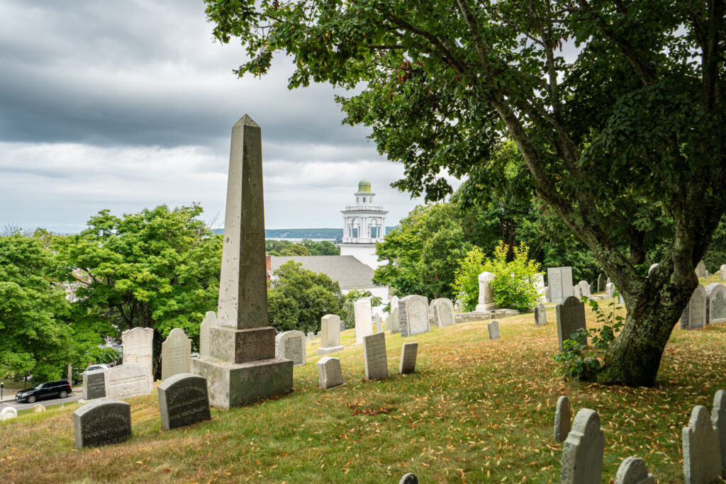 view of gravestones and a church steeple from burial hill plymouth ma