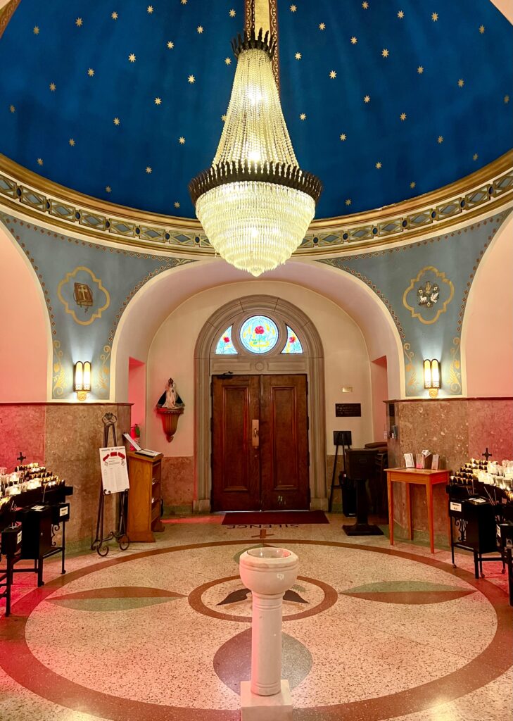 interior of saint elizabeth catholic church, one of the top landmarks eureka springs ar, photo shows interior of bell tower with chandelier and painted blue ceiling