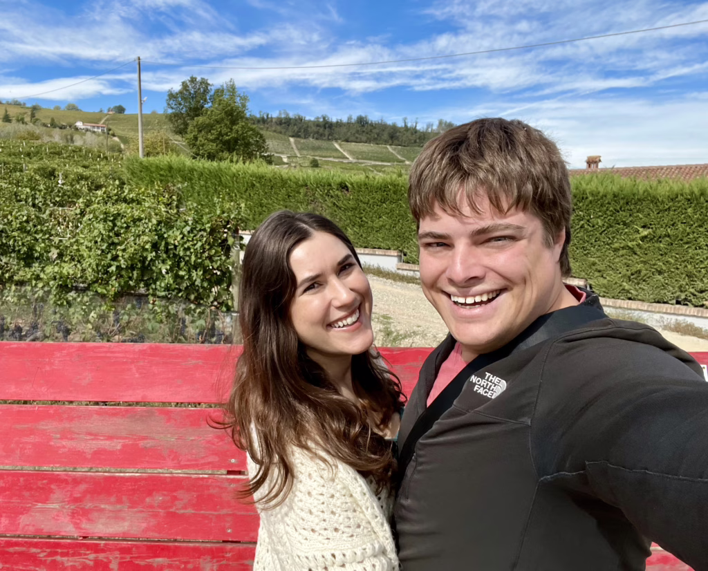 kate storm and jeremy storm taking a selfie on the giant red bench in la morra langhe piedmont italy