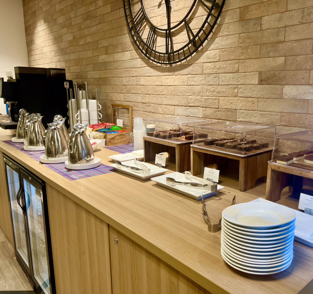 snacks and drinks laid out on a wooden counter at the london euston caledonian sleeper lounge