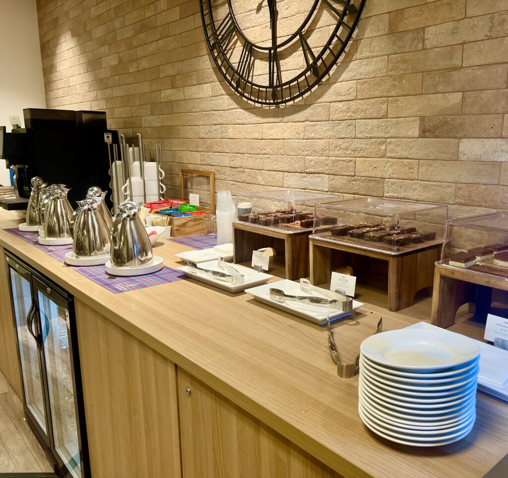 snacks and drinks laid out on a wooden counter at the london euston caledonian sleeper lounge