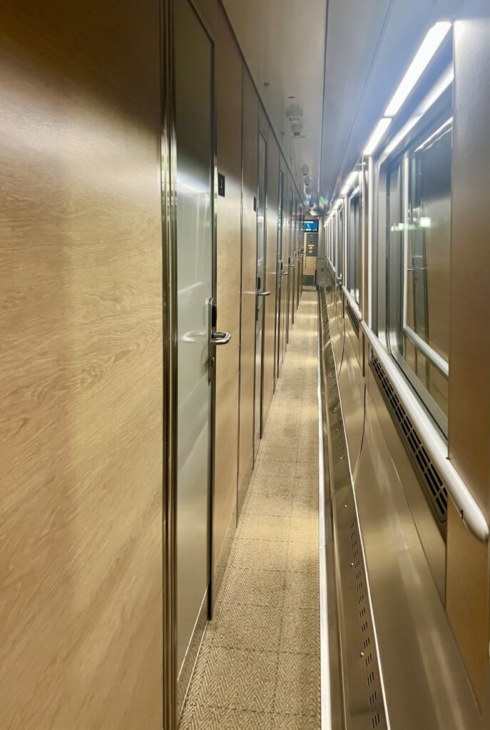 narrow aisle on the caledonian sleeper overnight train from london to scotland with cabin doors to the left
