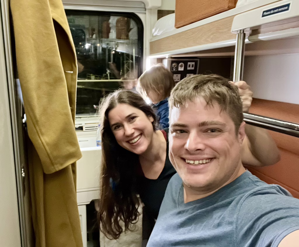 kate storm and jeremy storm taking a selfie in a club en suite cabin on the caledonian sleeper train from london to inverness