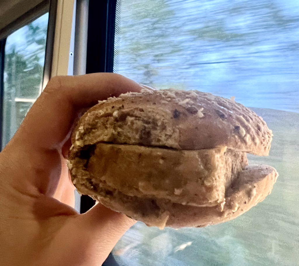 sausage bap being held up to the window on the caledonian sleeper train from london to inverness