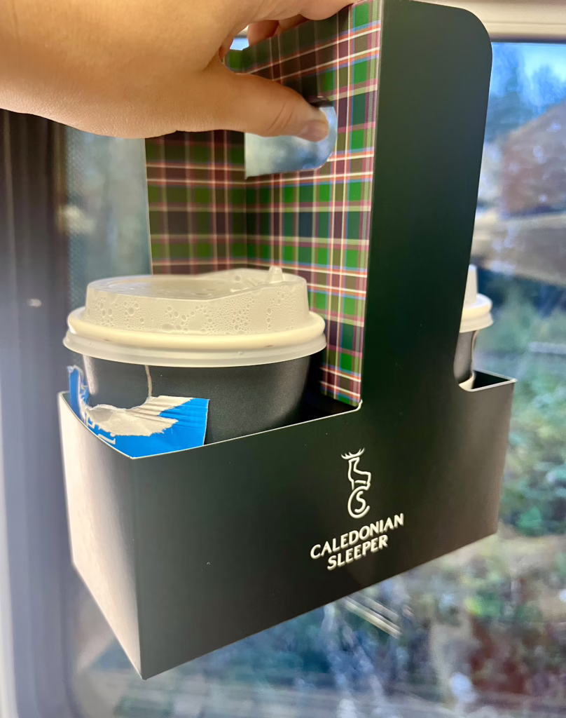 two disposable cups with tea on the caledonian sleeper train