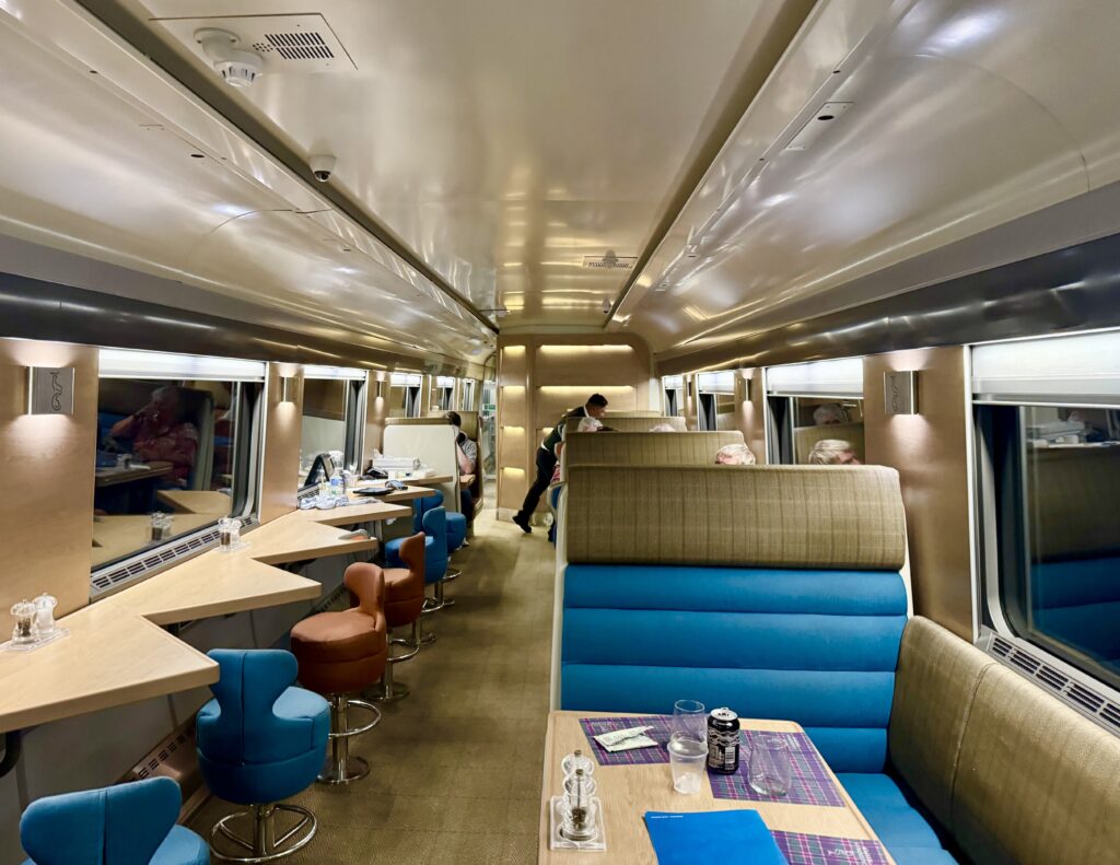 club car of the caledonian sleeper train from london to scotland showing a few booths and a row of seats
