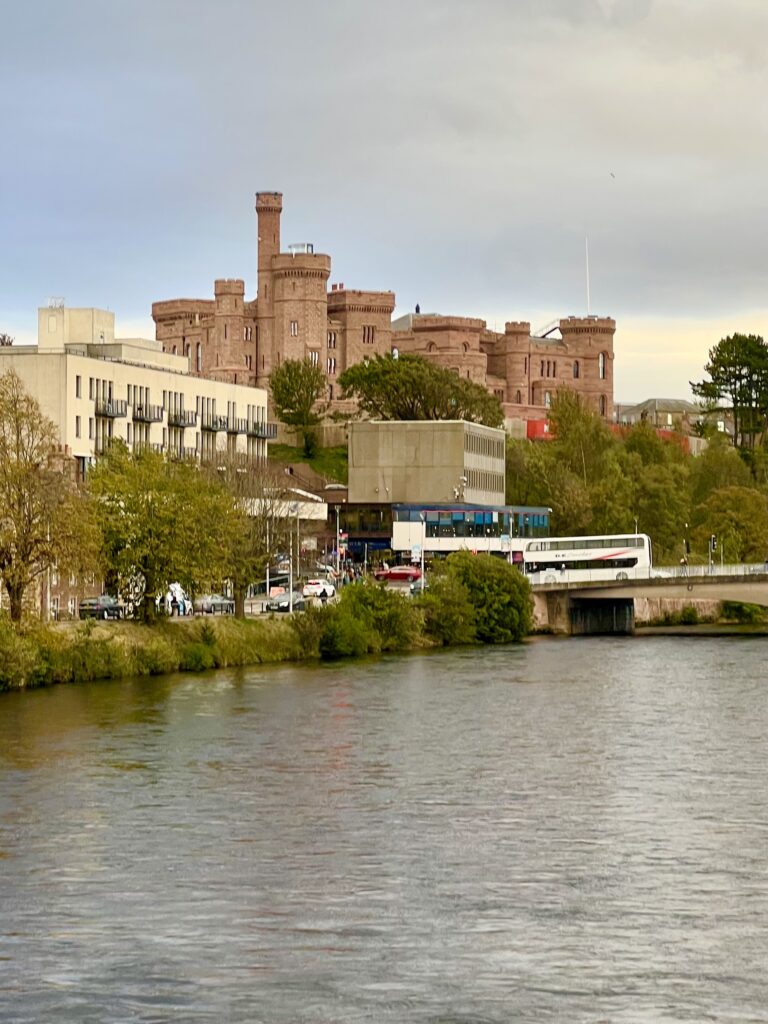 view of inverness castle and inverness museum from the center of river ness, two of the best places to visit in inverness scotland