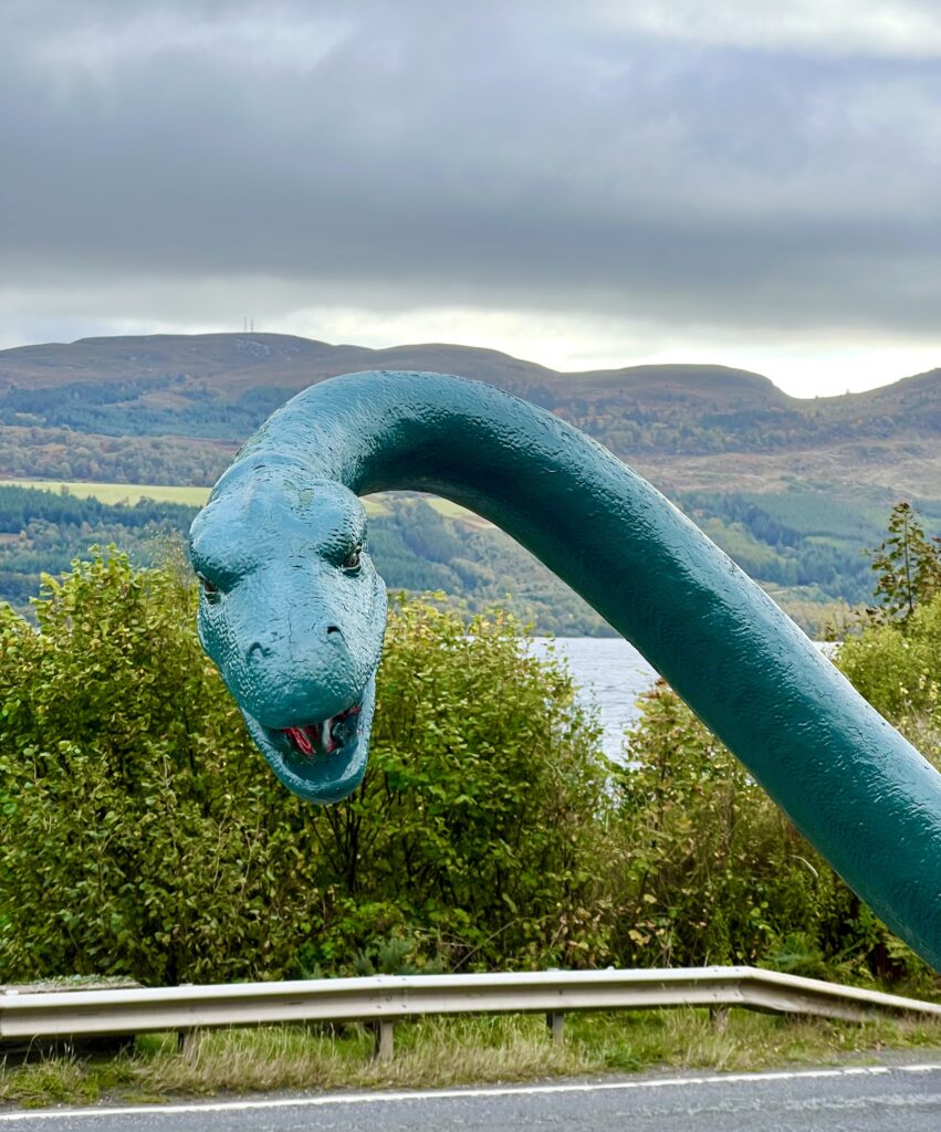 photo of the face of loch ness monster, a green statue in front of the clansman hotel